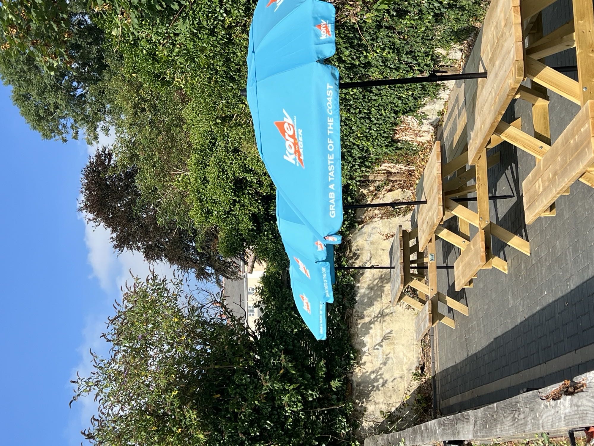 Picnic tables and parasols in the beer garden at The Dolphin Inn