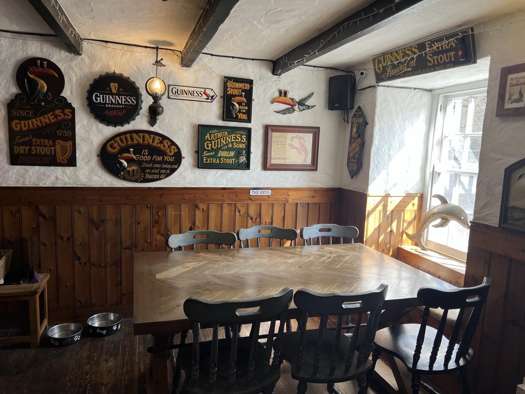 The Snug at The Dolphin Inn, a cosy corner with a dog bed by the window